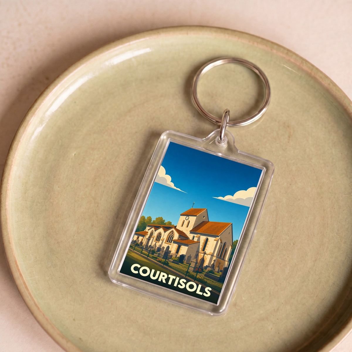 Porte-clés souvenir de la ville de Courtisols avec une illustration stylisée de son église.