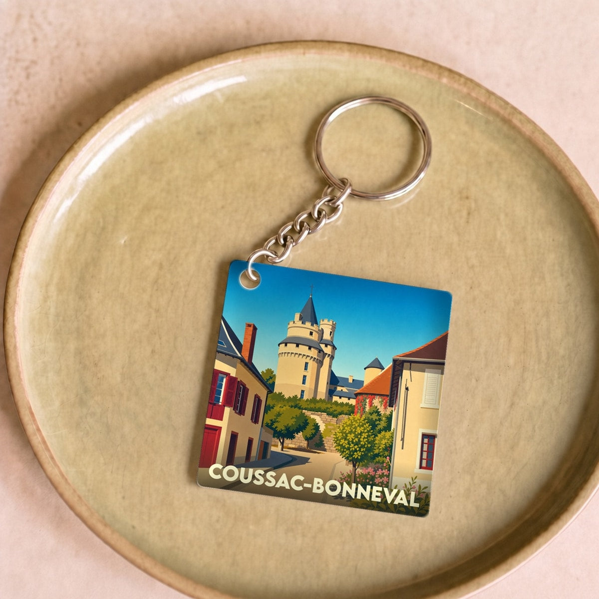 Porte-clés souvenir de la ville de Coussac-Bonneval avec une illustration stylisée de son château.