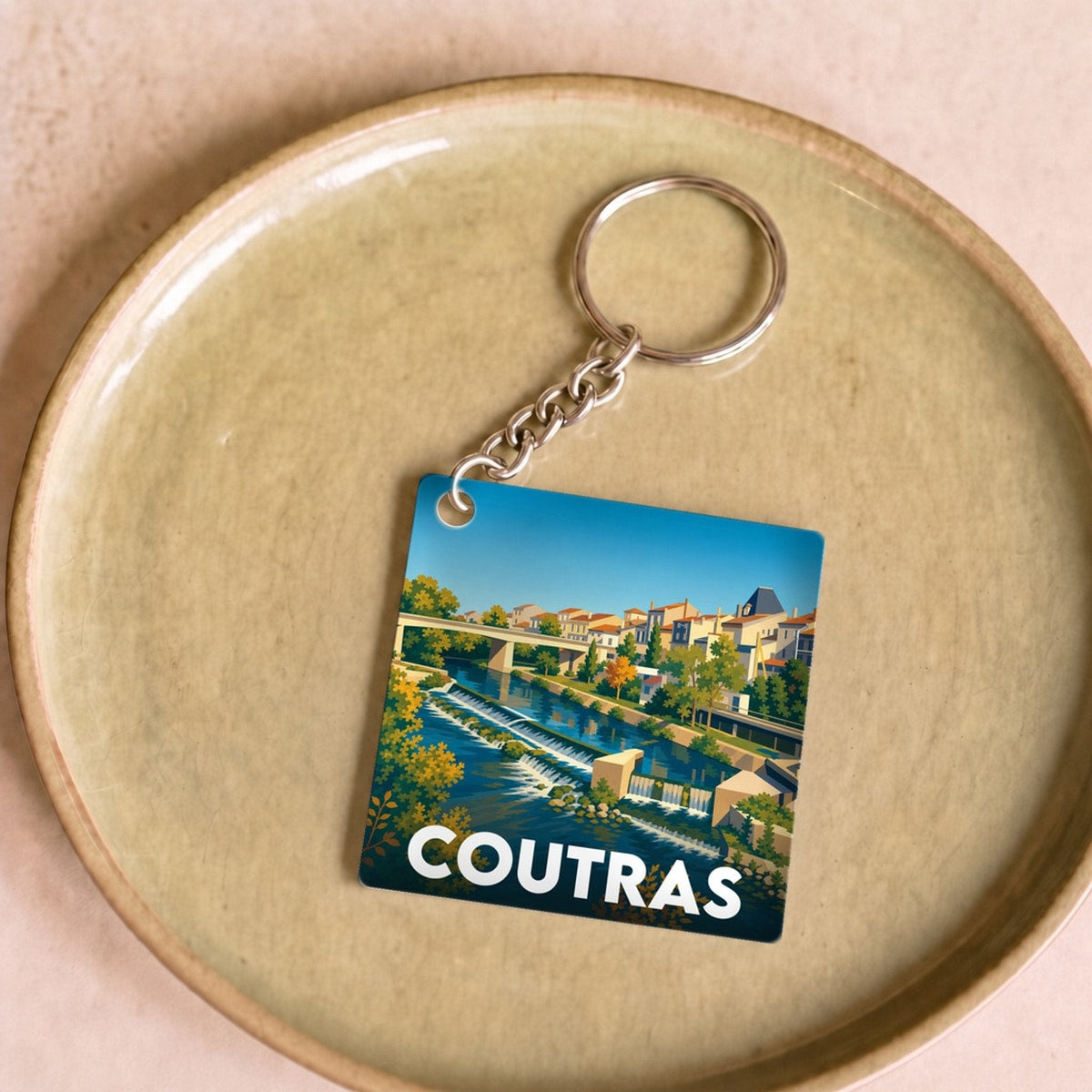 Porte-clés souvenir de la ville de Coutras avec une illustration stylisée.