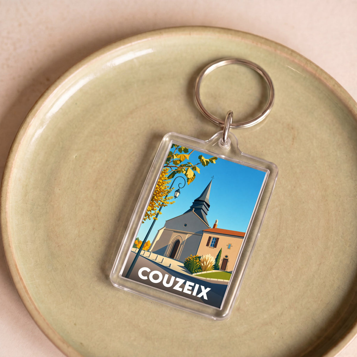 Porte-clés souvenir de la ville de Couzeix avec une illustration stylisée.