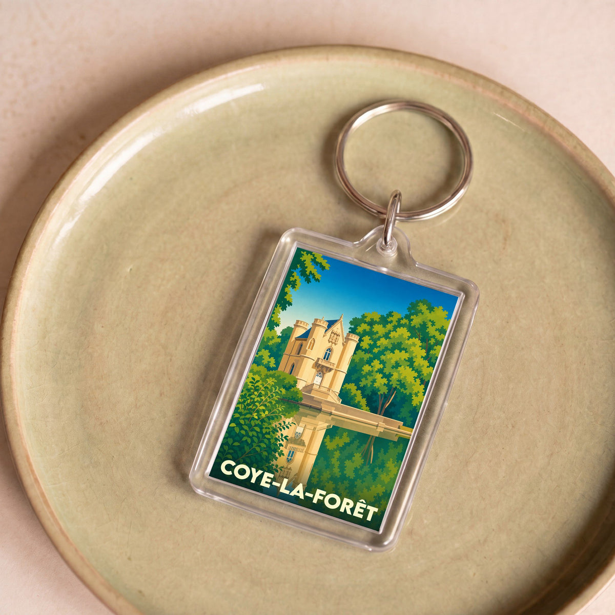 Porte-clés souvenir de la ville de Coye-la-Forêt avec une illustration stylisée de son château.