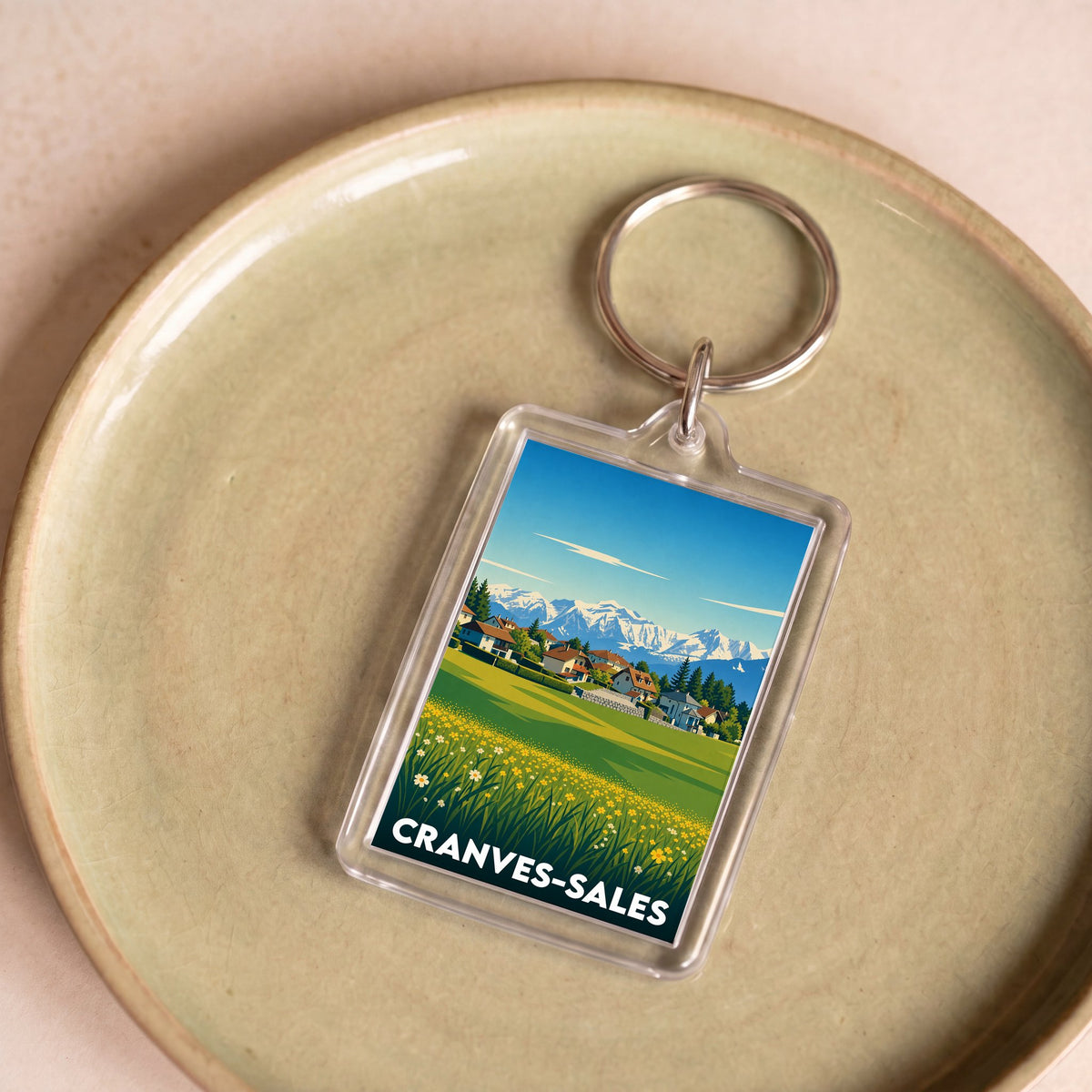 Porte-clés souvenir de la ville de Cranves-Sales avec une illustration stylisée de montagnes.