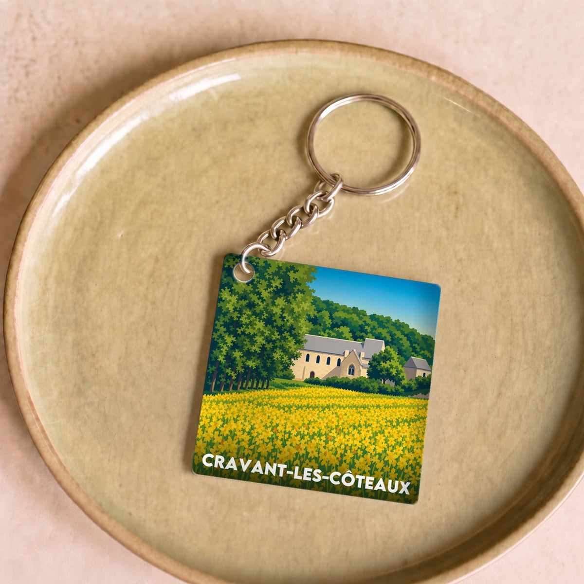 Porte-clés souvenir de la ville de Cravant-les-Côteaux avec une illustration stylisée.