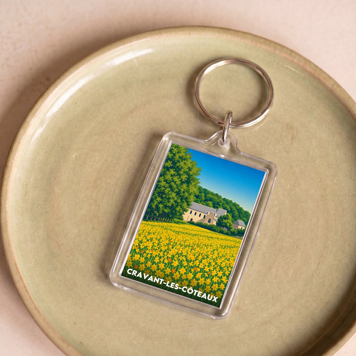 Porte-clés souvenir de la ville de Cravant-les-Côteaux avec une illustration stylisée.