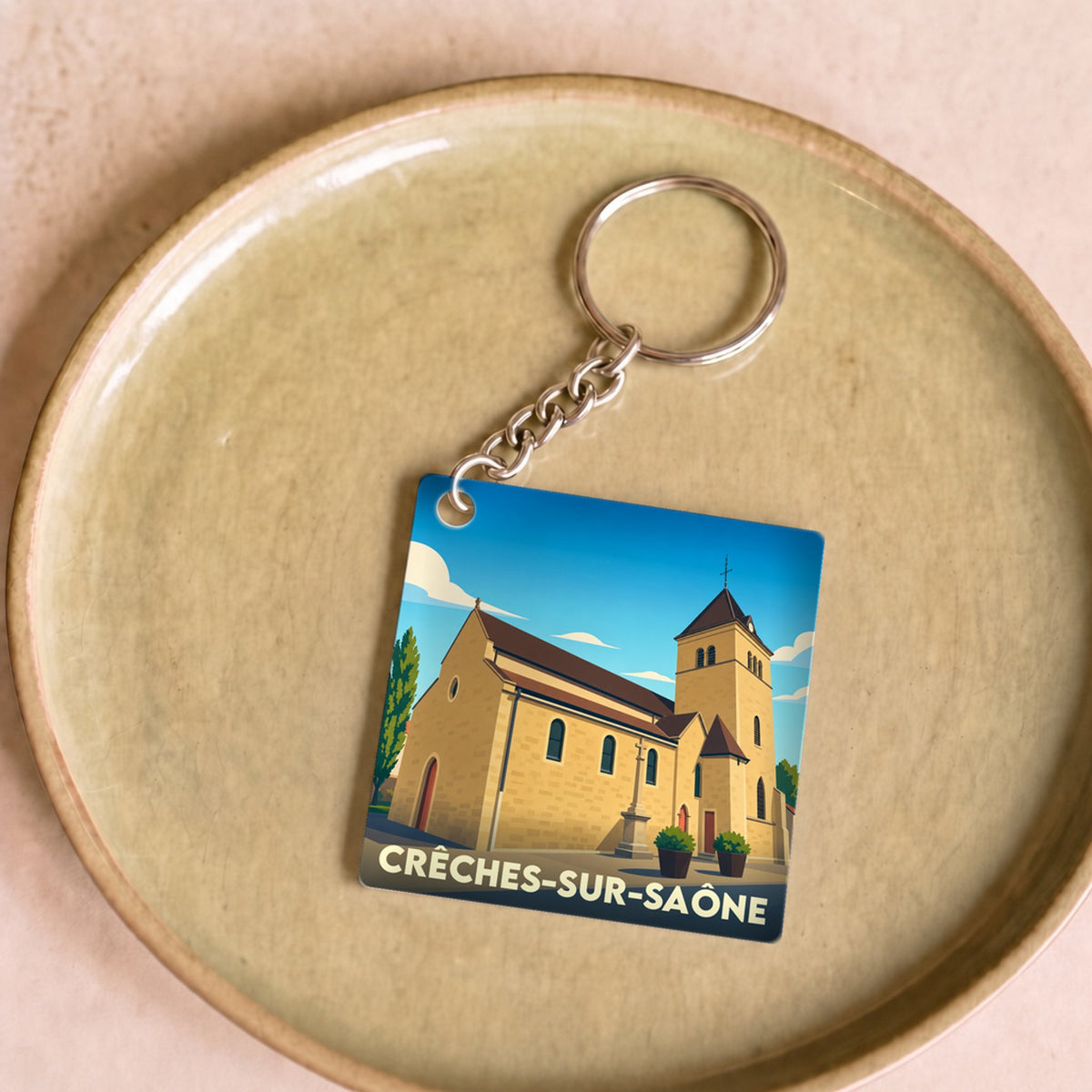 Porte-clés souvenir de la ville de Crêches-sur-Saône avec une illustration stylisée.