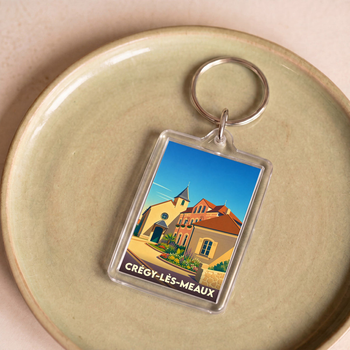 Porte-clés souvenir de la ville de Crégy-lès-Meaux avec une illustration stylisée.