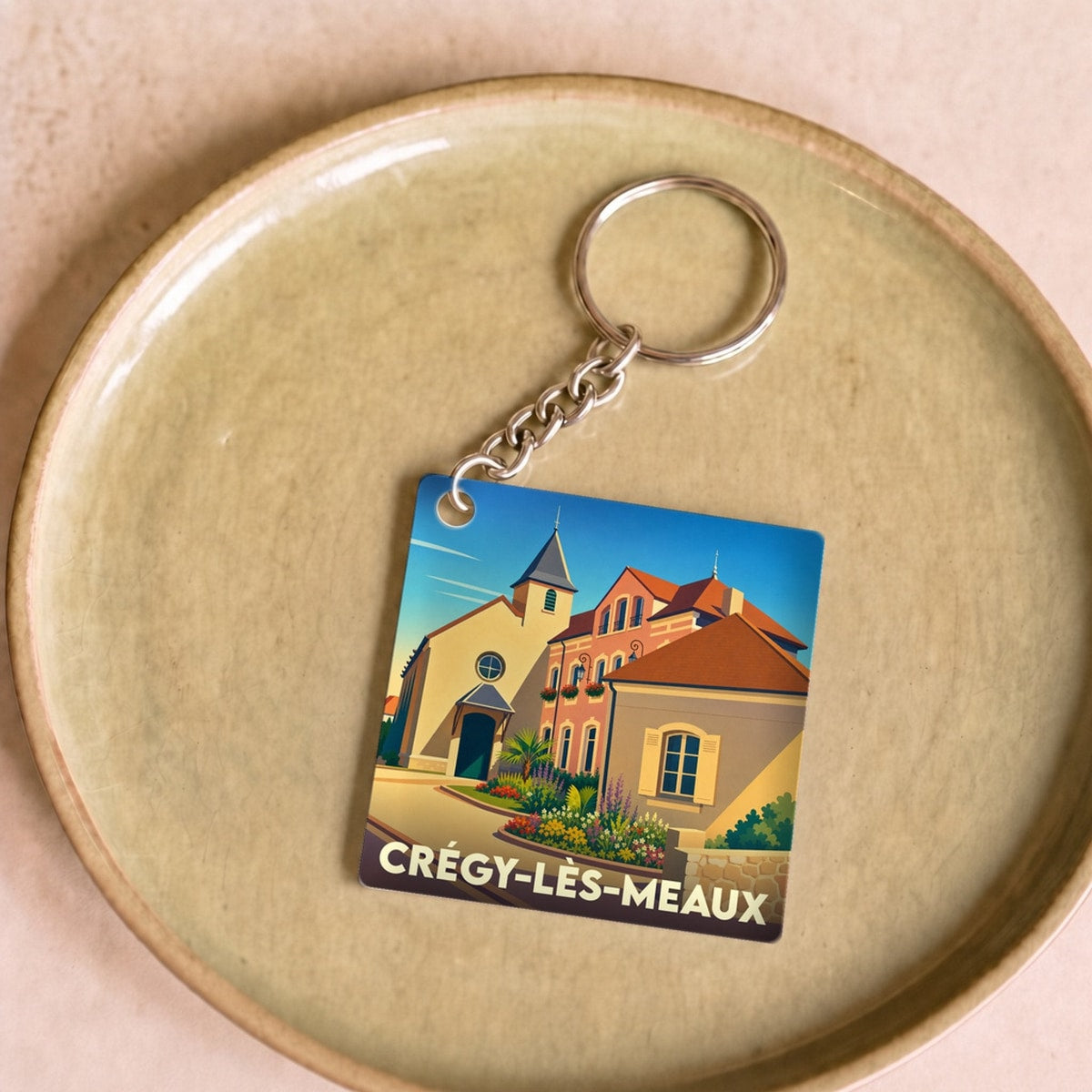Porte-clés souvenir de la ville de Crégy-lès-Meaux avec une illustration stylisée.