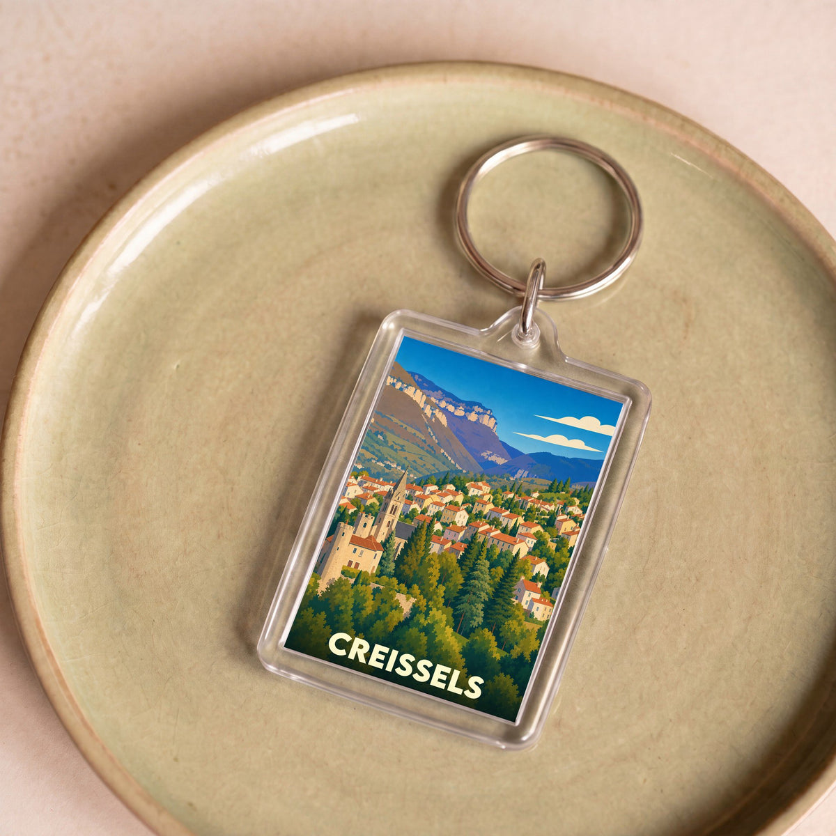 Porte-clés souvenir de la ville de Creissels avec une illustration stylisée.