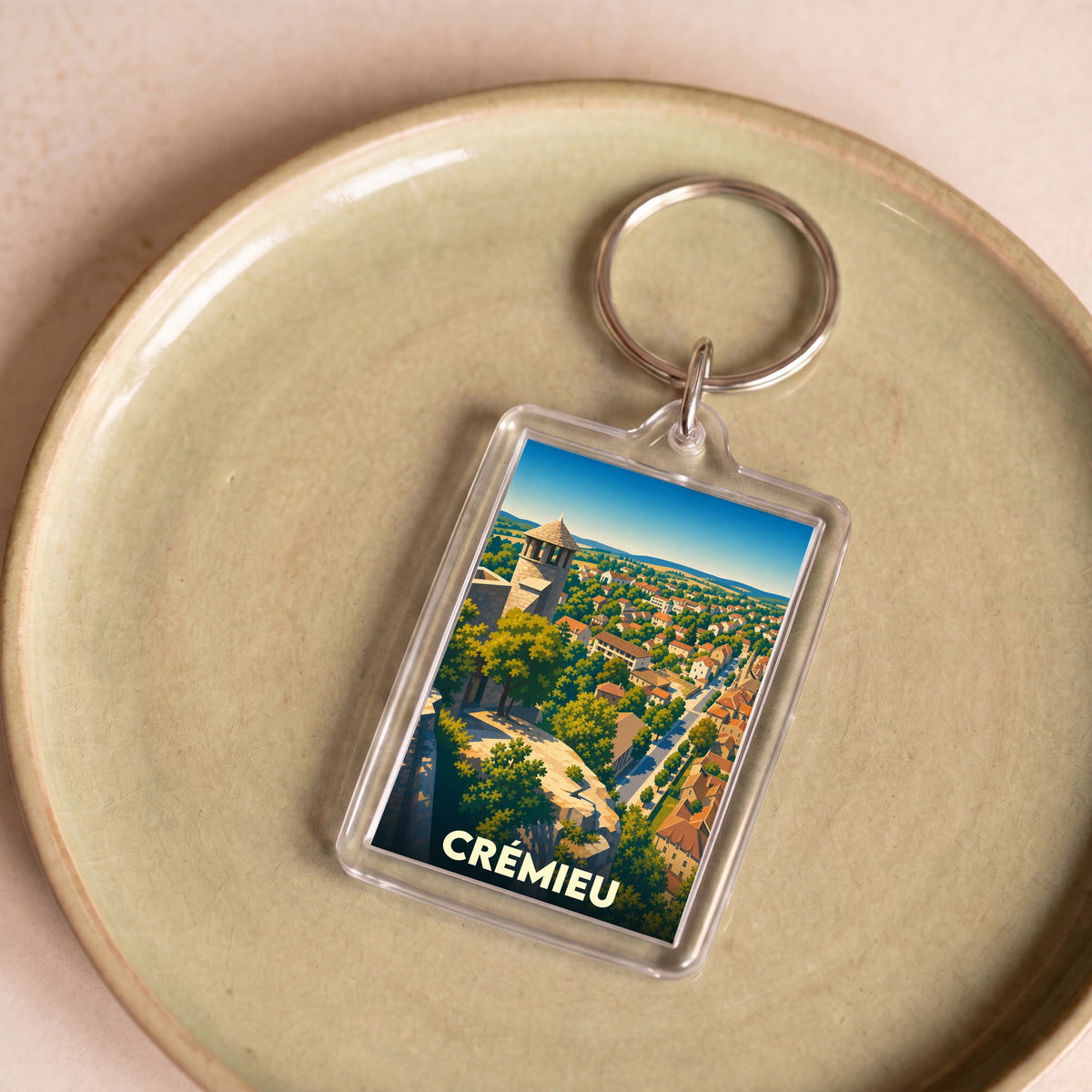 Porte-clés souvenir de la ville de Crémieu avec une illustration stylisée.