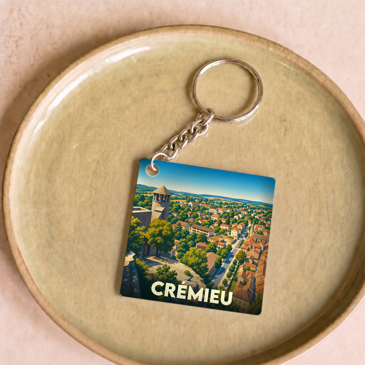 Porte-clés souvenir de la ville de Crémieu avec une illustration stylisée.