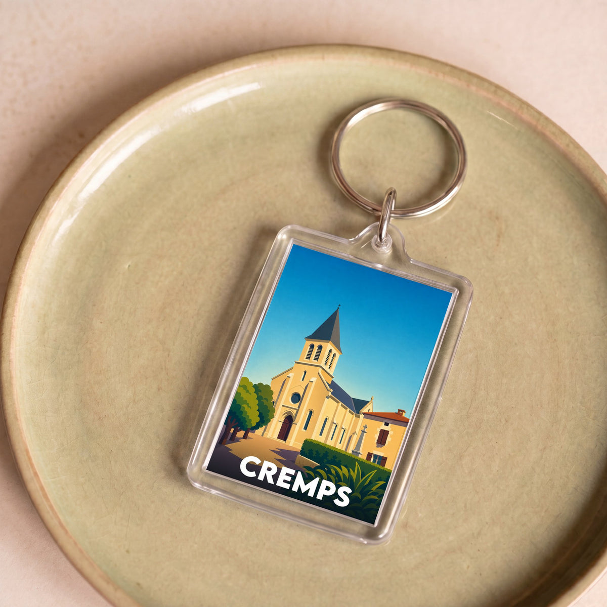 Porte-clés souvenir de la ville de Cremps avec une illustration stylisée.