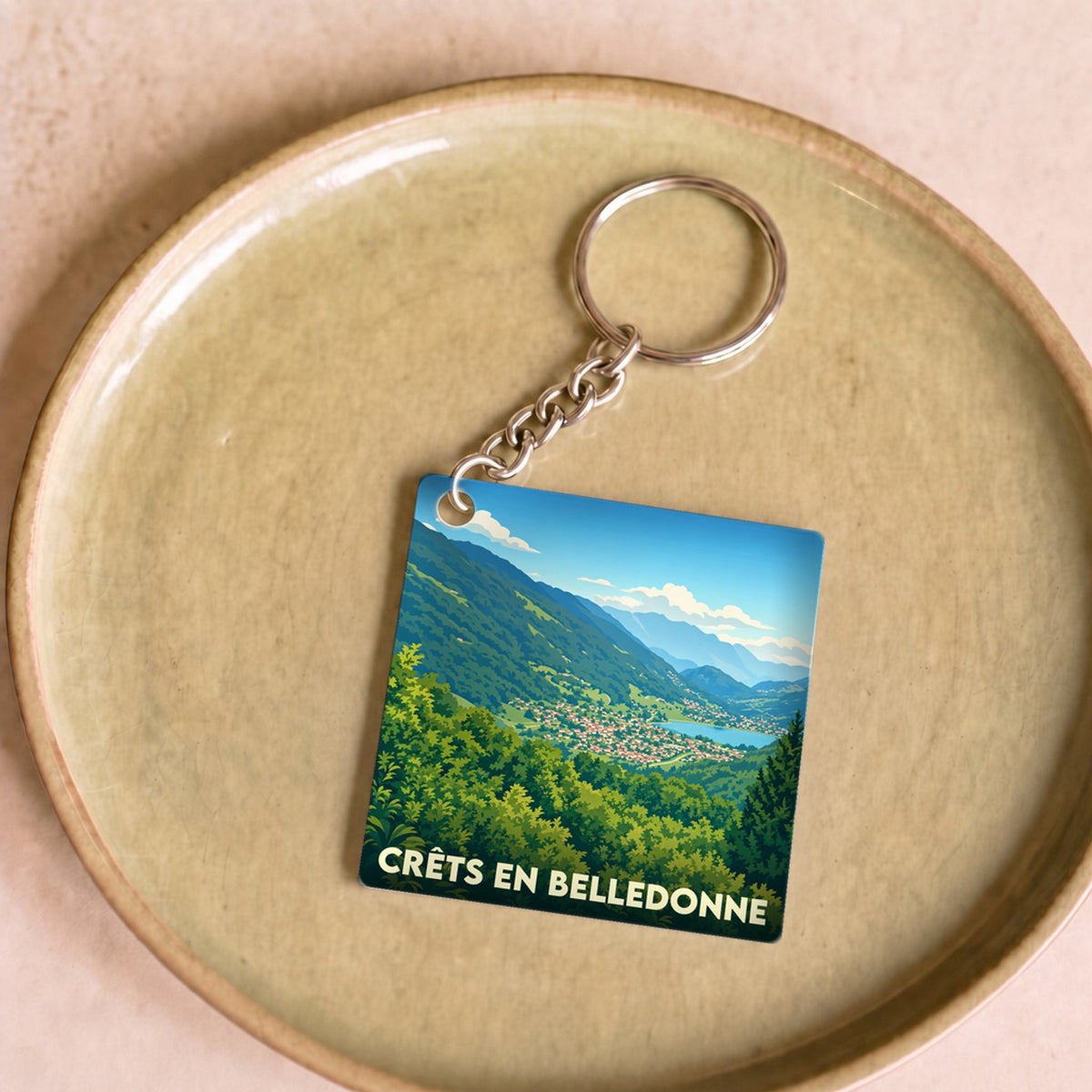Porte-clés souvenir de la ville de Crêts en Belledonne avec une illustration de paysage montagneux.