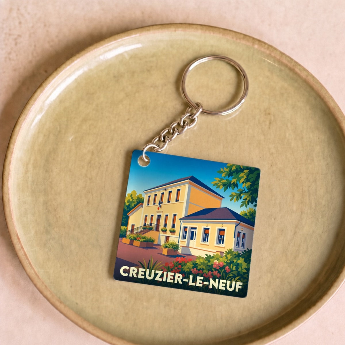 Porte-clés souvenir de la ville de Creuzier-le-Neuf avec une illustration stylisée.