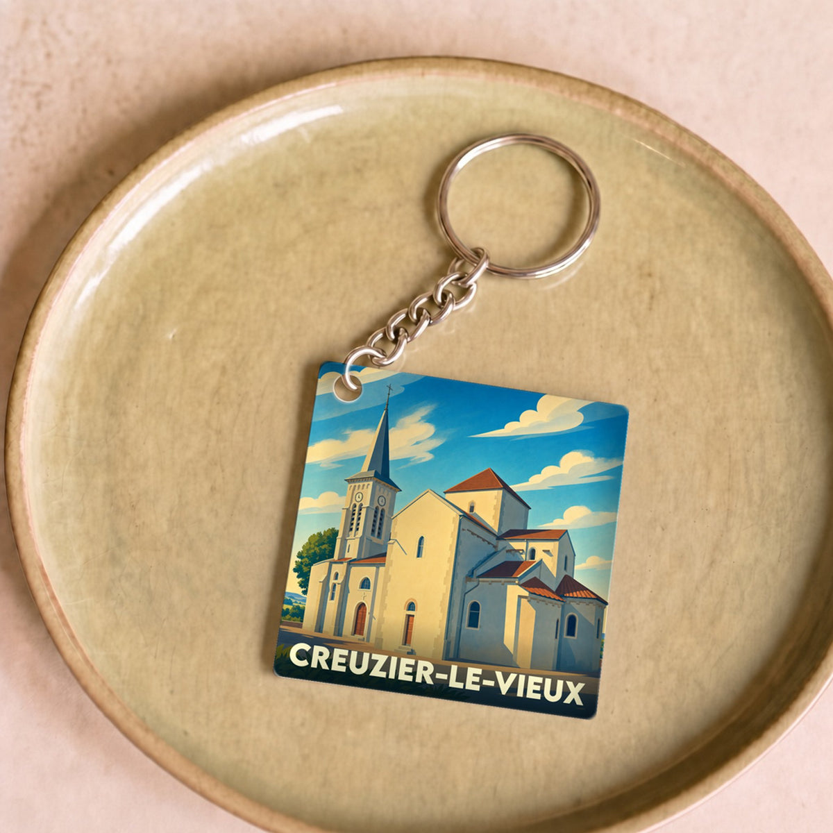 Porte-clés souvenir de la ville de Creuzier-le-Vieux avec une illustration stylisée de son église.
