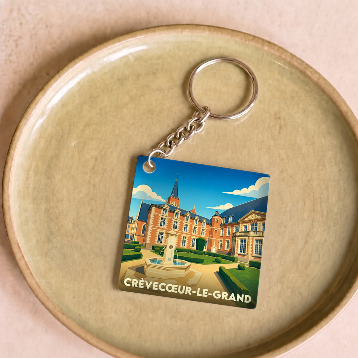 Porte-clés souvenir de la ville de Crèvecœur-le-Grand avec une illustration stylisée de son château.