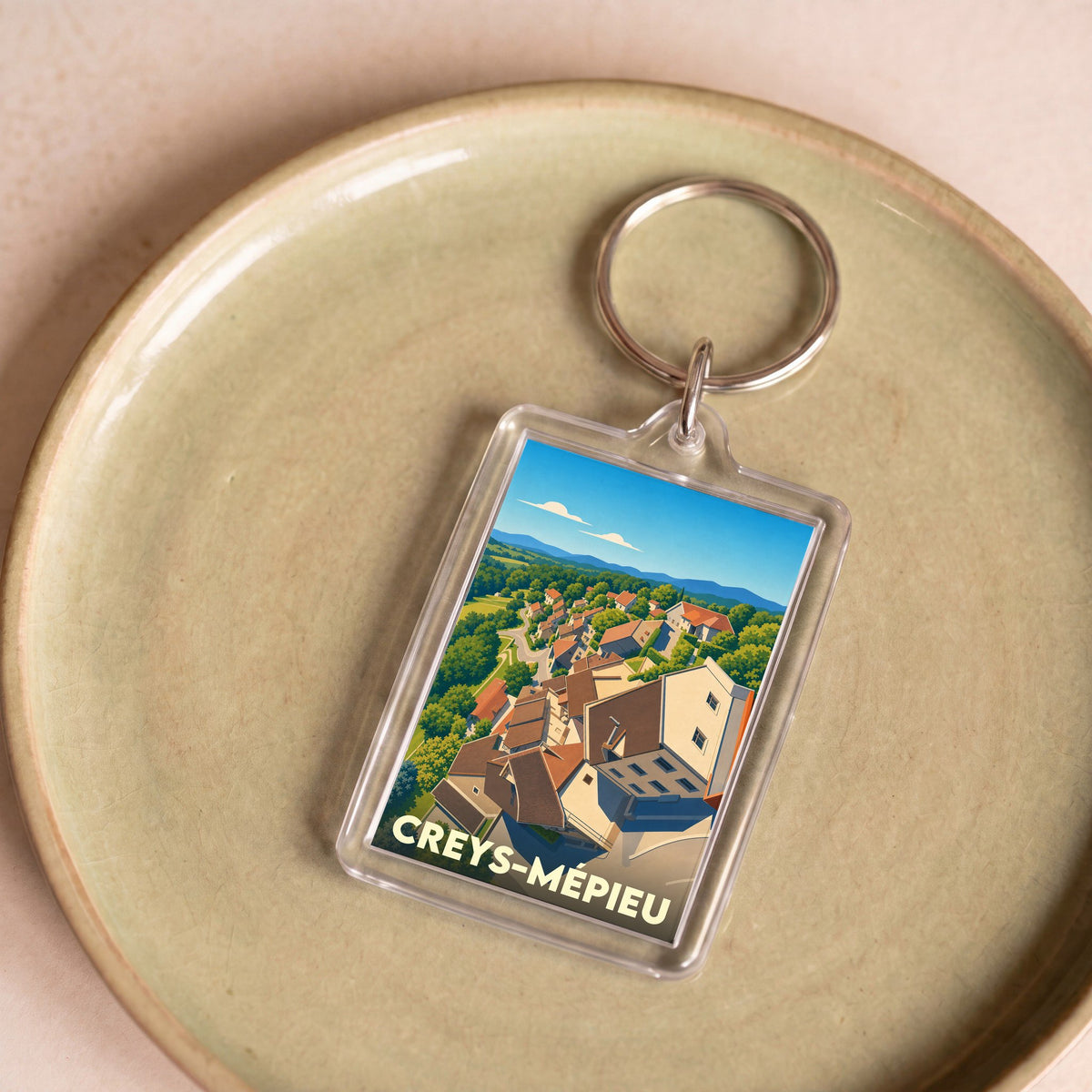 Porte-clés souvenir de la ville de Creys-Mépieu avec une illustration stylisée.