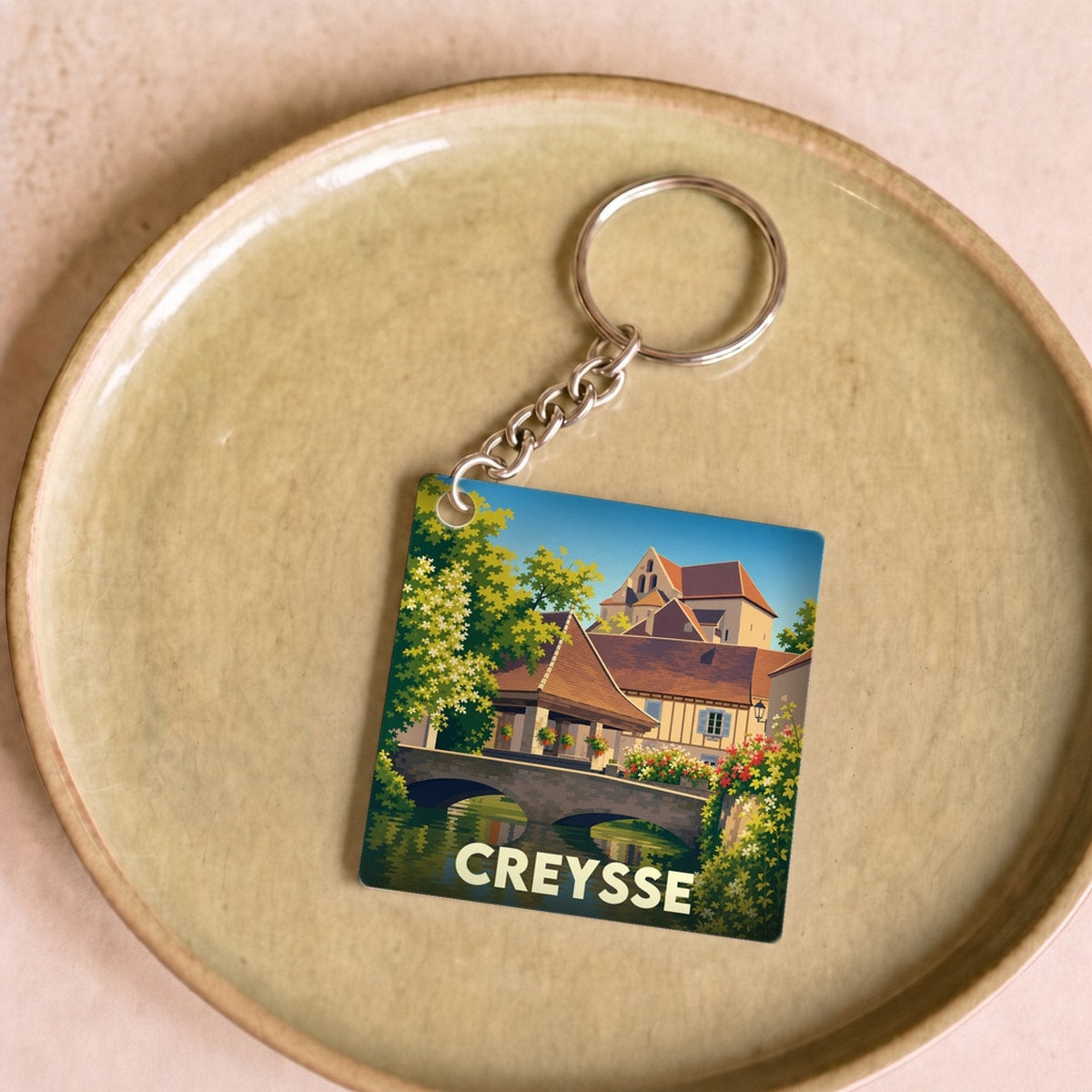 Porte-clés souvenir de la ville de Creysse avec une illustration stylisée.