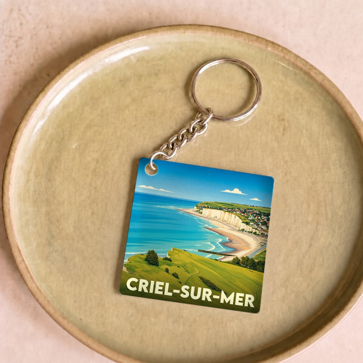 Porte-clés souvenir de la ville de Criel-sur-Mer avec une illustration stylisée de son littoral.
