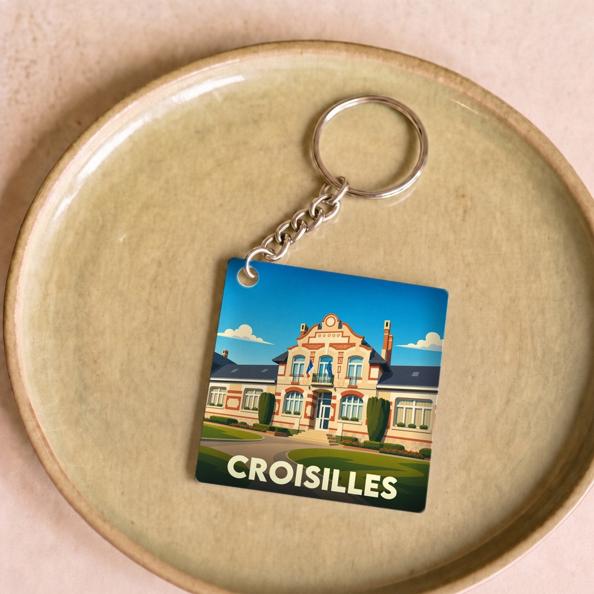 Porte-clés souvenir de la ville de Croisilles avec une illustration stylisée de son hôtel de ville.