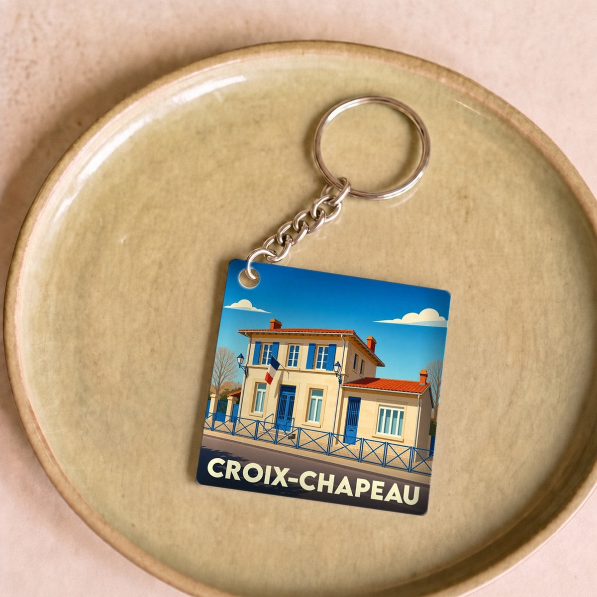 Porte-clés souvenir de la ville de Croix-Chapeau avec une illustration stylisée.