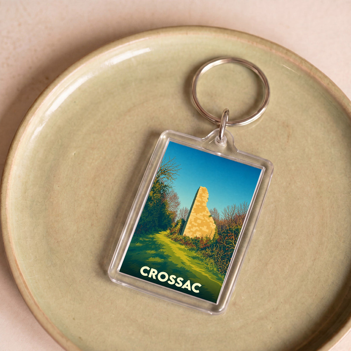 Porte-clés souvenir de la ville de Crossac avec une illustration stylisée de ruines historiques.