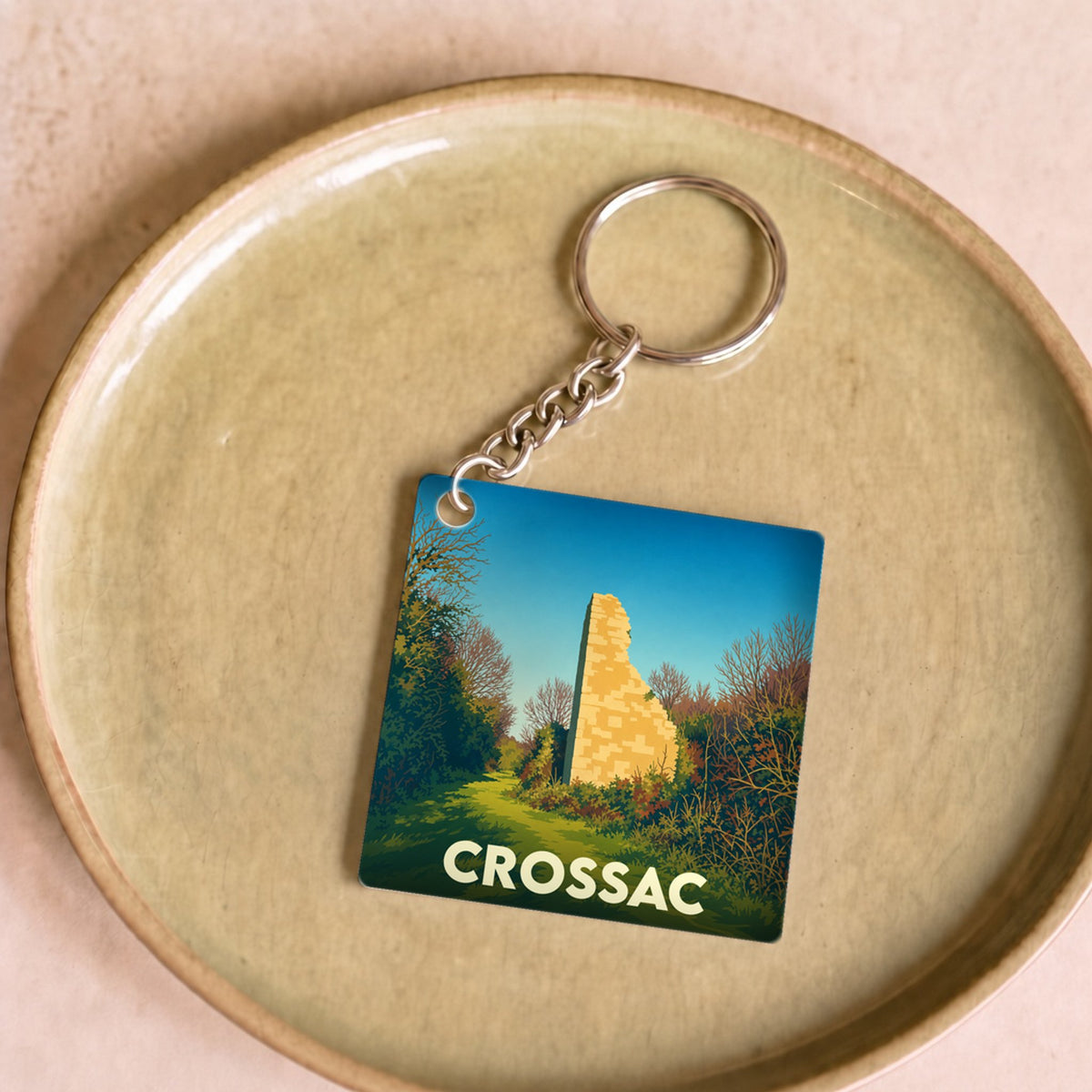 Porte-clés souvenir de la ville de Crossac avec une illustration stylisée de ruines historiques.