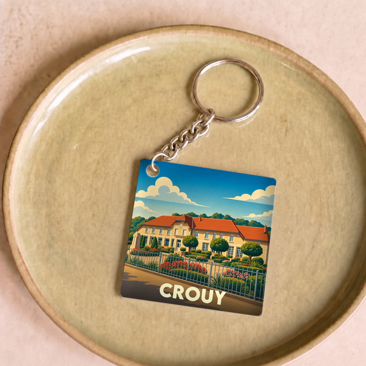 Porte-clés souvenir de la ville de Crouy avec une illustration stylisée.