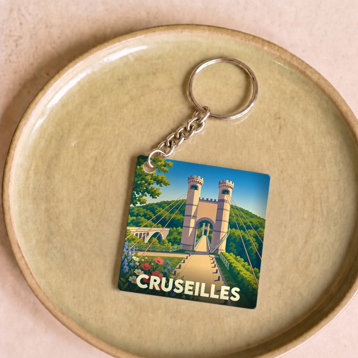 Porte-clés souvenir de la ville de Cruseilles avec une illustration stylisée du pont de la Caille.