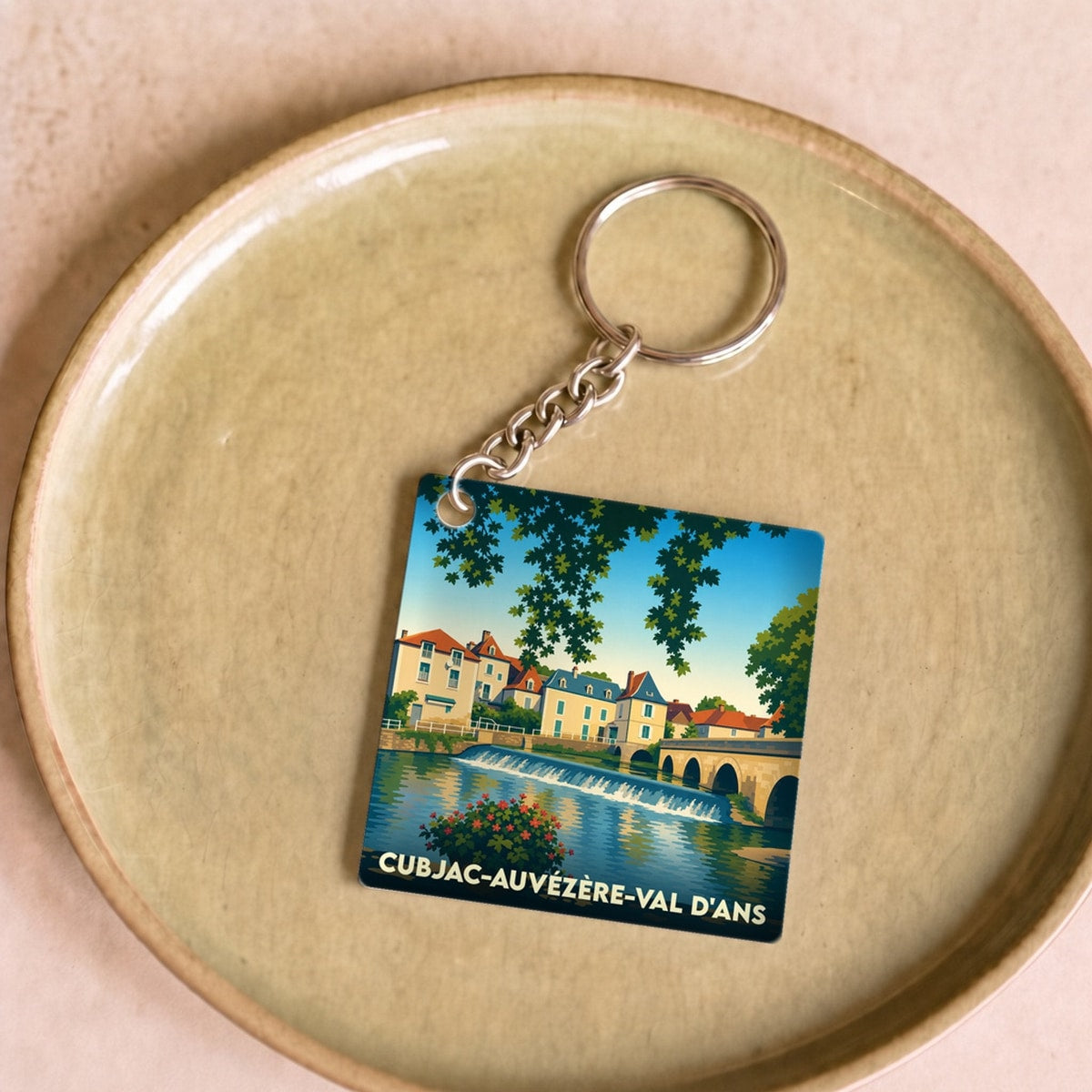 Porte-clés souvenir de Cubjac-Auvézère-Val d'Ans avec une illustration stylisée des bords de l'Auvézère.