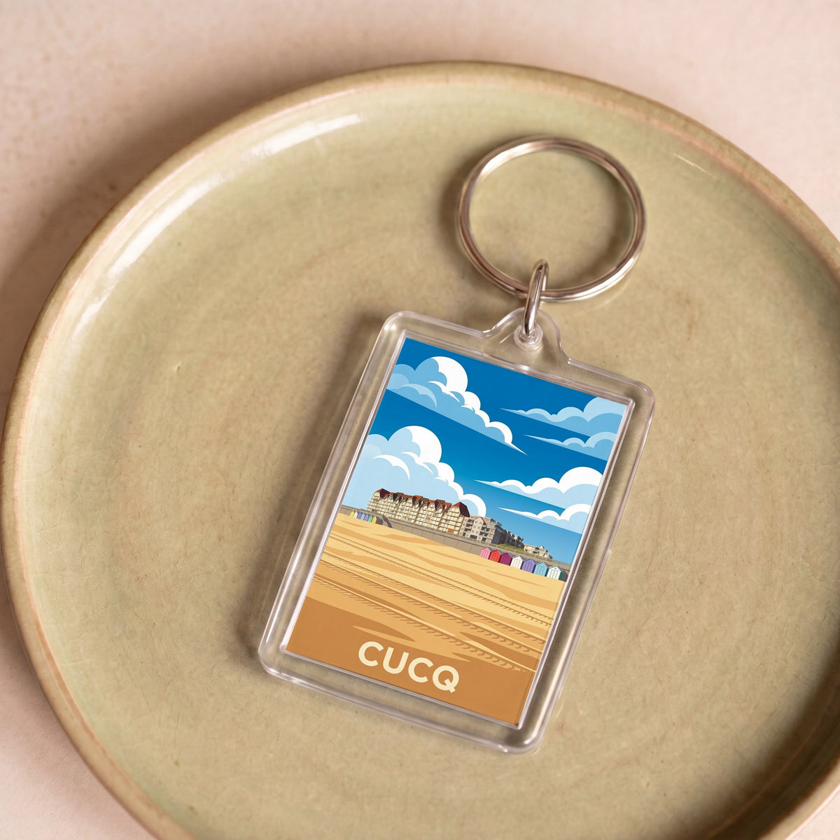Porte-clés souvenir de la ville de Cucq avec une illustration stylisée de sa plage.