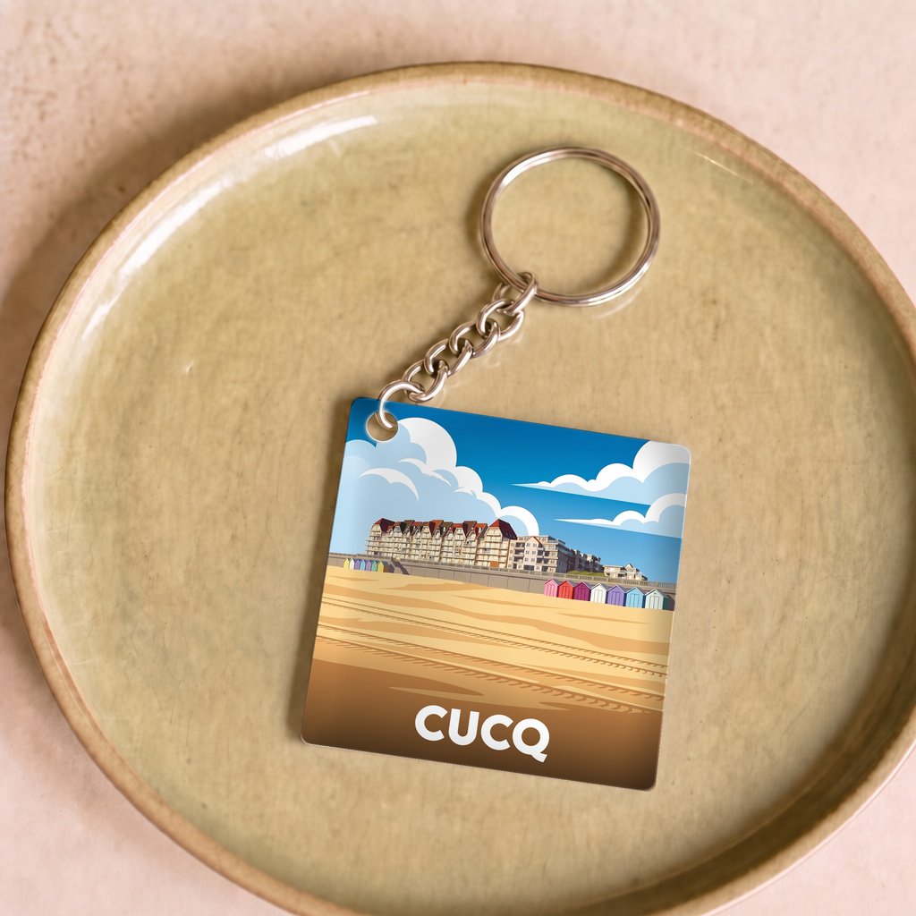 Porte-clés souvenir de la ville de Cucq avec une illustration stylisée de sa plage.