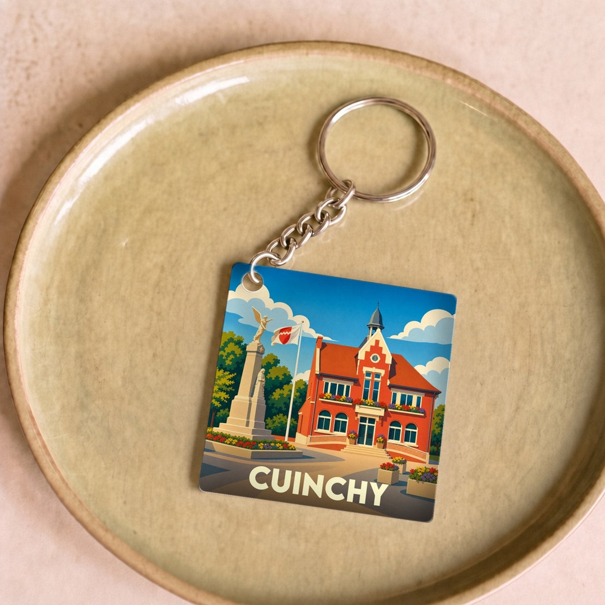 Porte-clés souvenir de la ville de Cuinchy avec une illustration stylisée.