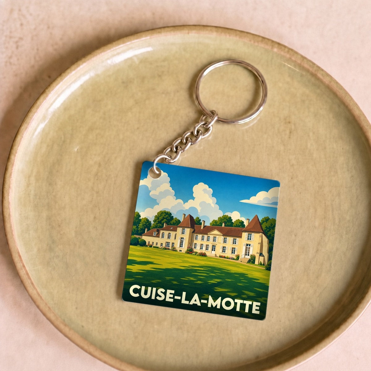 Porte-clés souvenir de la ville de Cuise-la-Motte avec une illustration stylisée d'un château.