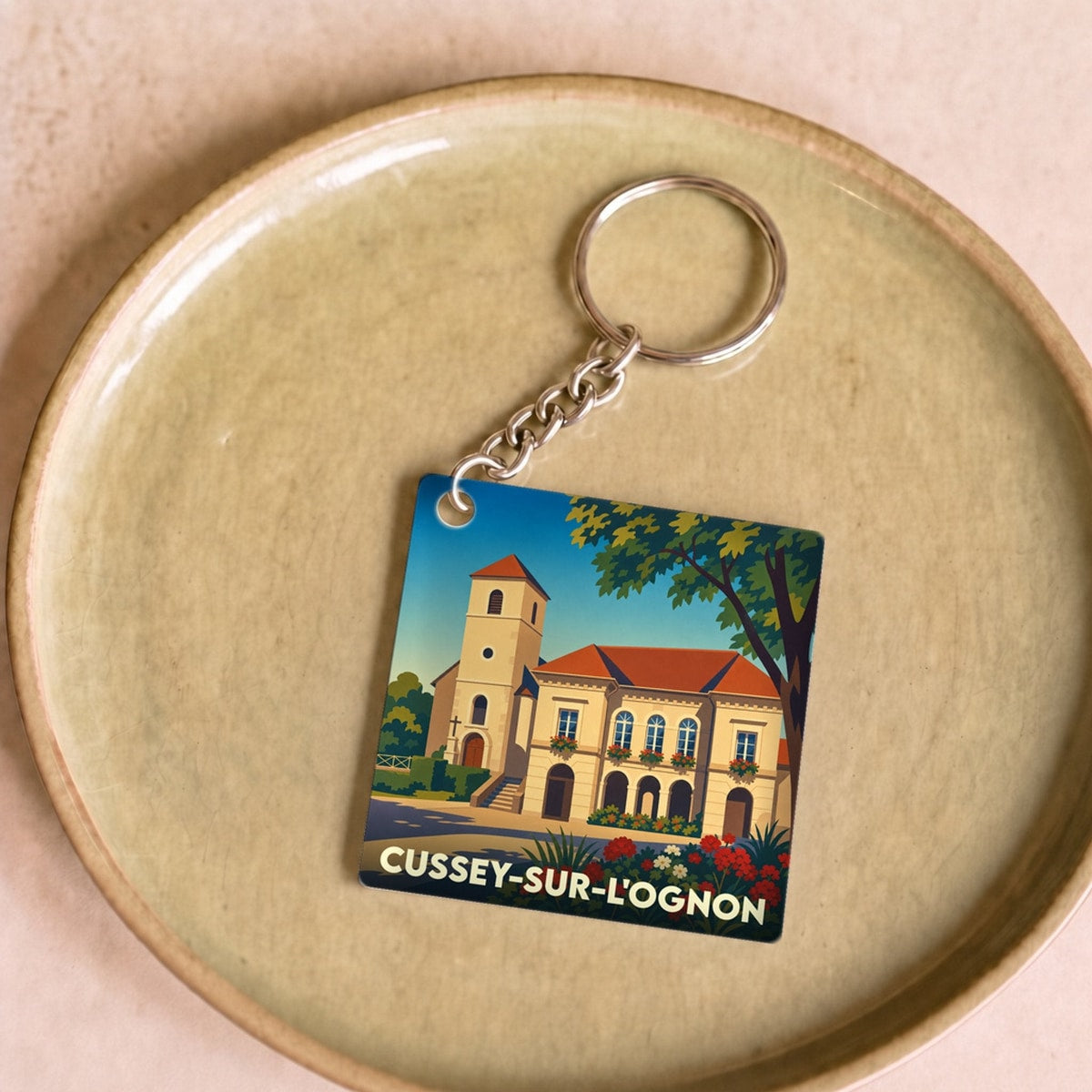 Porte-clés souvenir de la ville de Cussey-sur-l'Ognon avec une illustration stylisée.