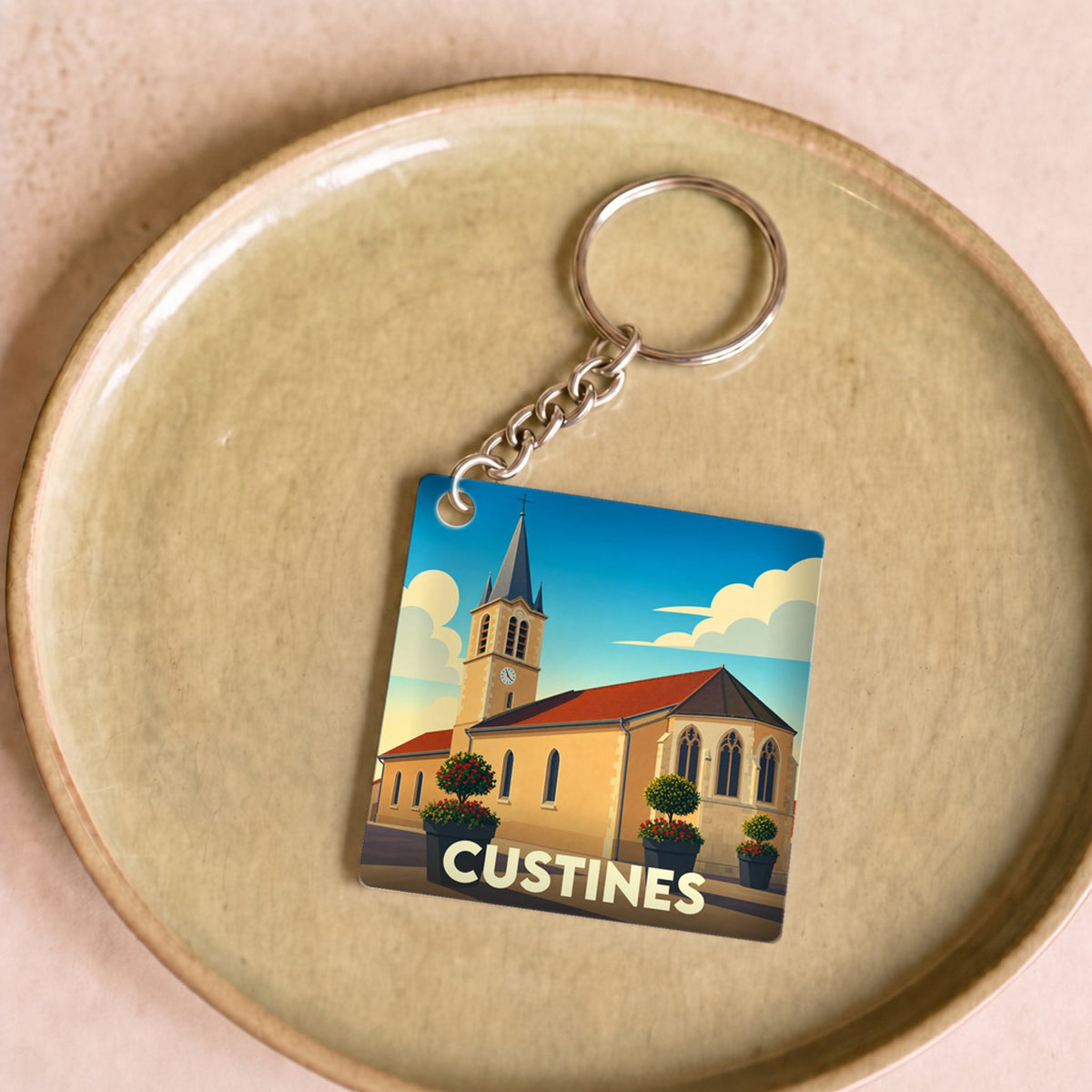 Porte-clés souvenir de la ville de Custines avec une illustration stylisée de son église.