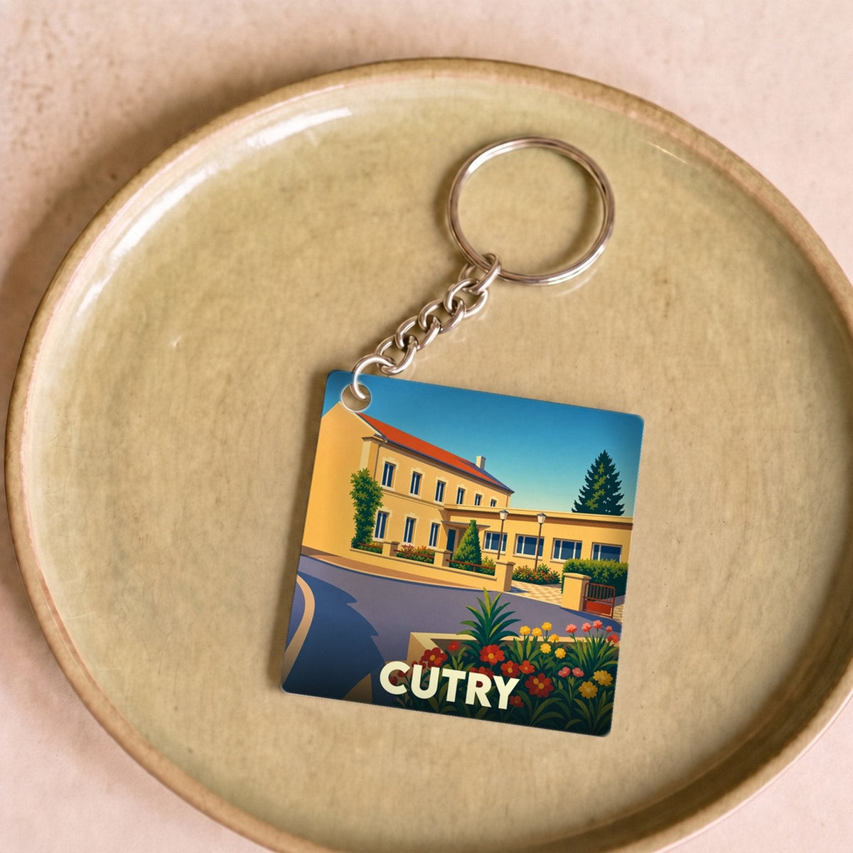 Porte-clés souvenir de la ville de Cutry avec une illustration stylisée et colorée.