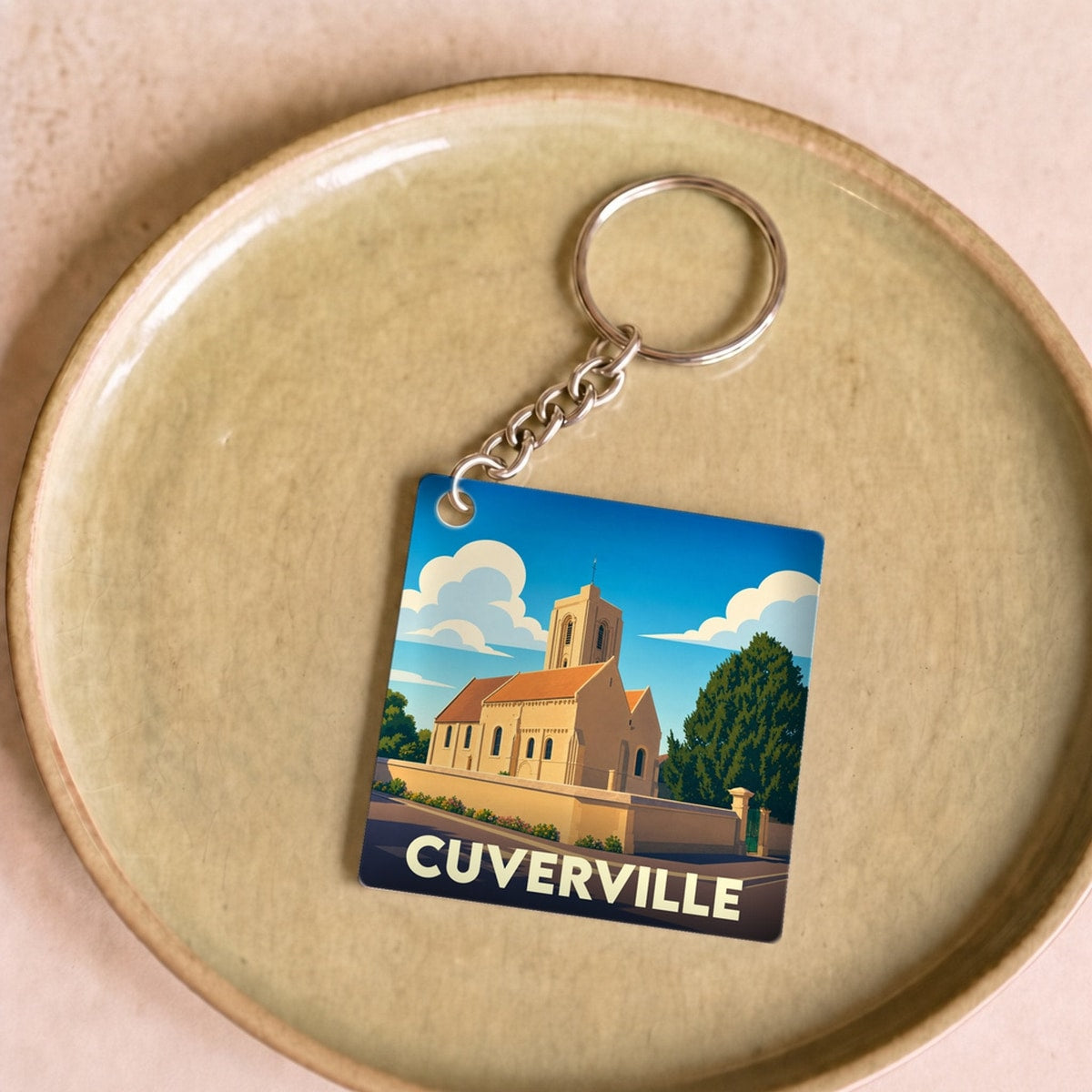 Porte-clés souvenir de la ville de Cuverville avec une illustration stylisée de son église.