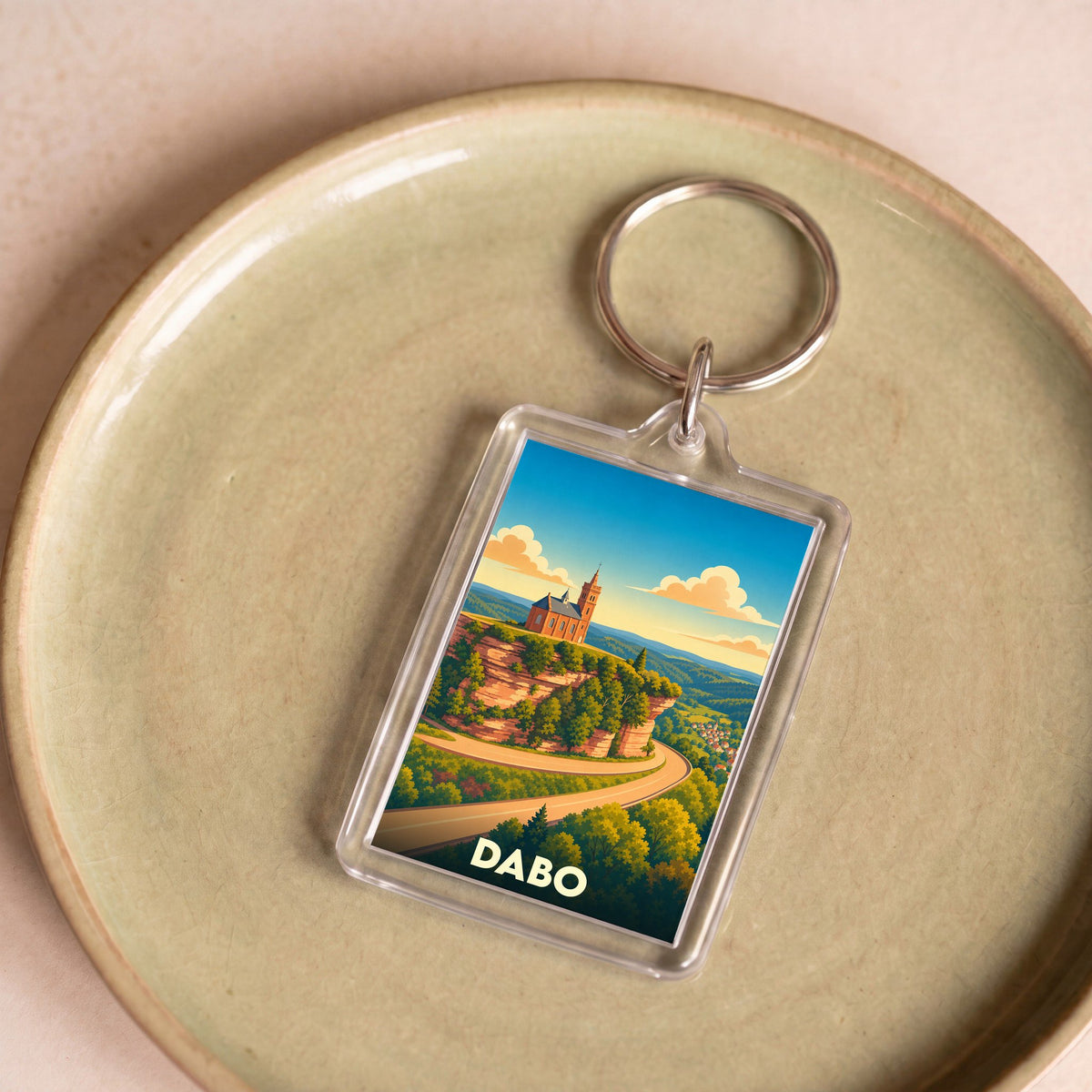 Porte-clés souvenir de la ville de Dabo avec une illustration stylisée de son rocher et sa chapelle.