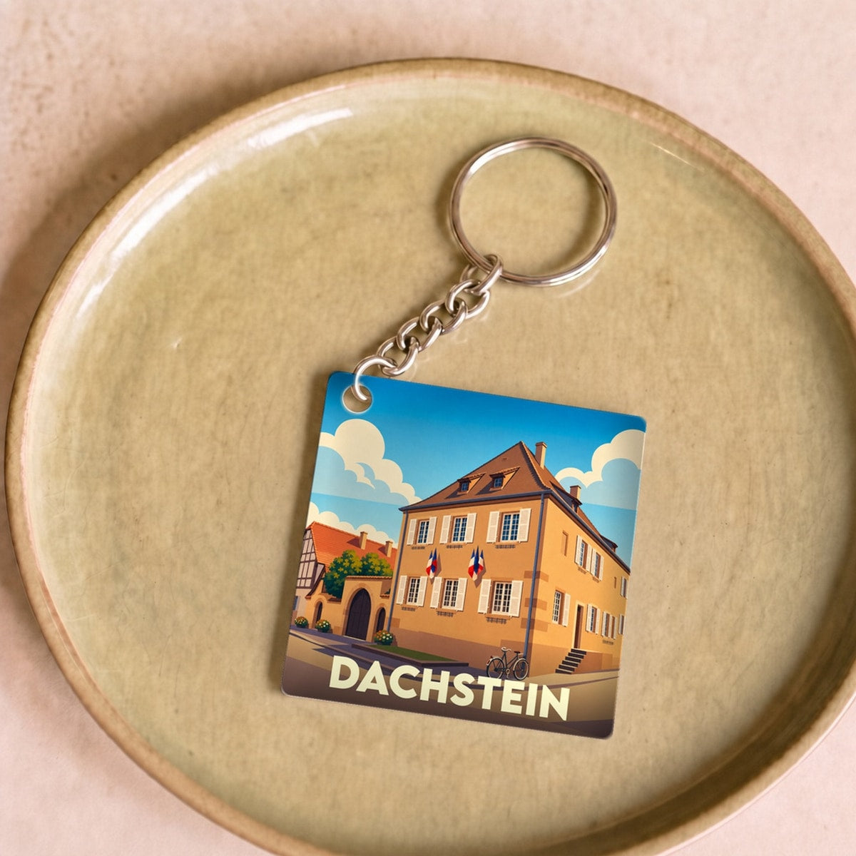 Porte-clés souvenir de la ville de Dachstein avec une illustration stylisée d'un bâtiment historique.