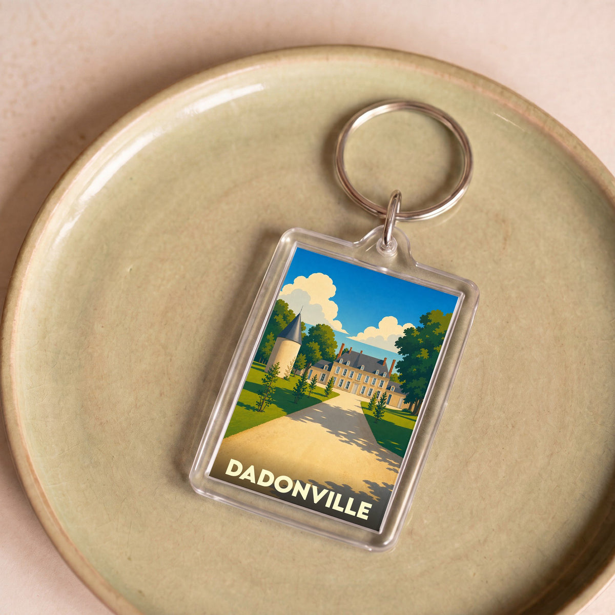 Porte-clés souvenir de la ville de Dadonville avec une illustration stylisée d'un château.