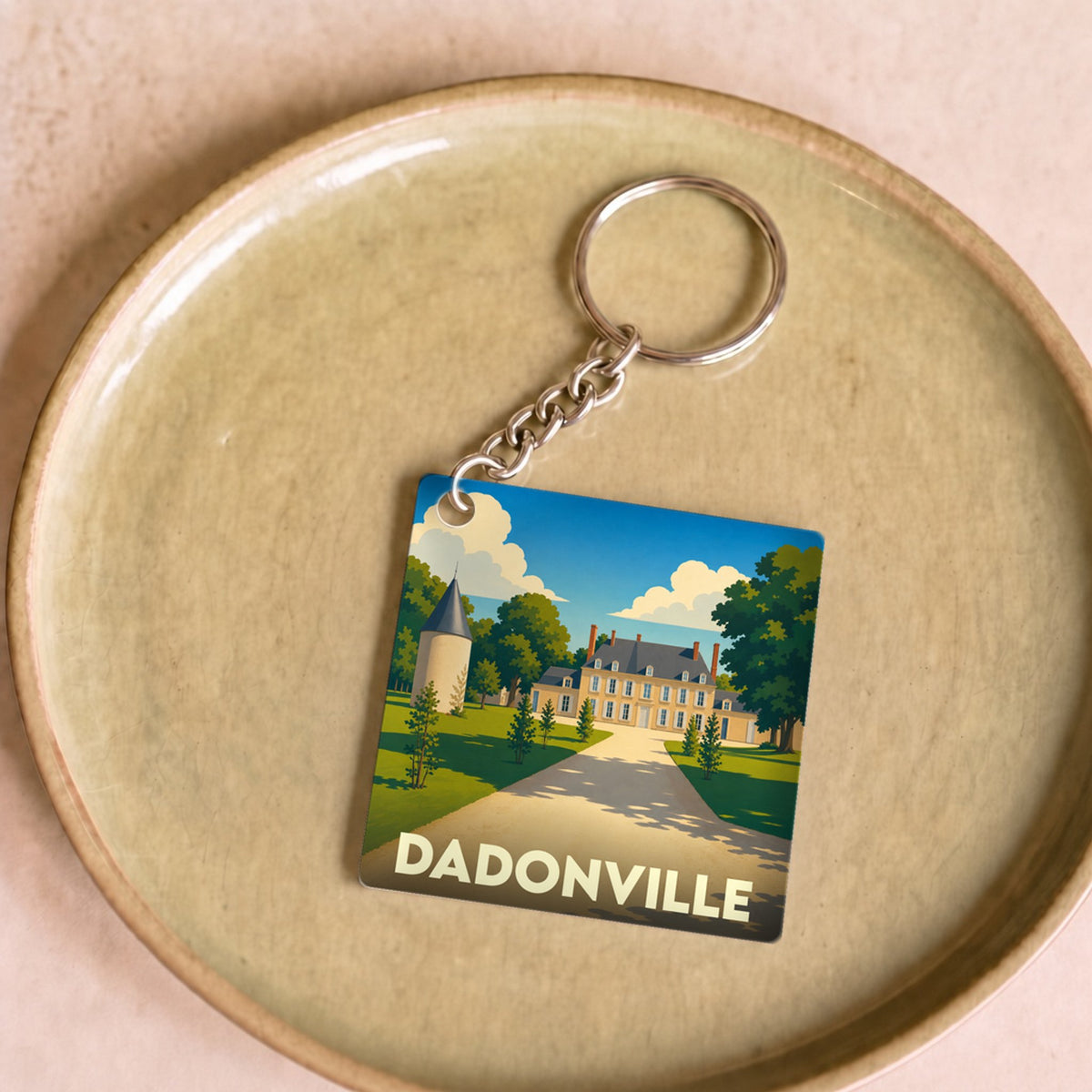Porte-clés souvenir de la ville de Dadonville avec une illustration stylisée d'un château.
