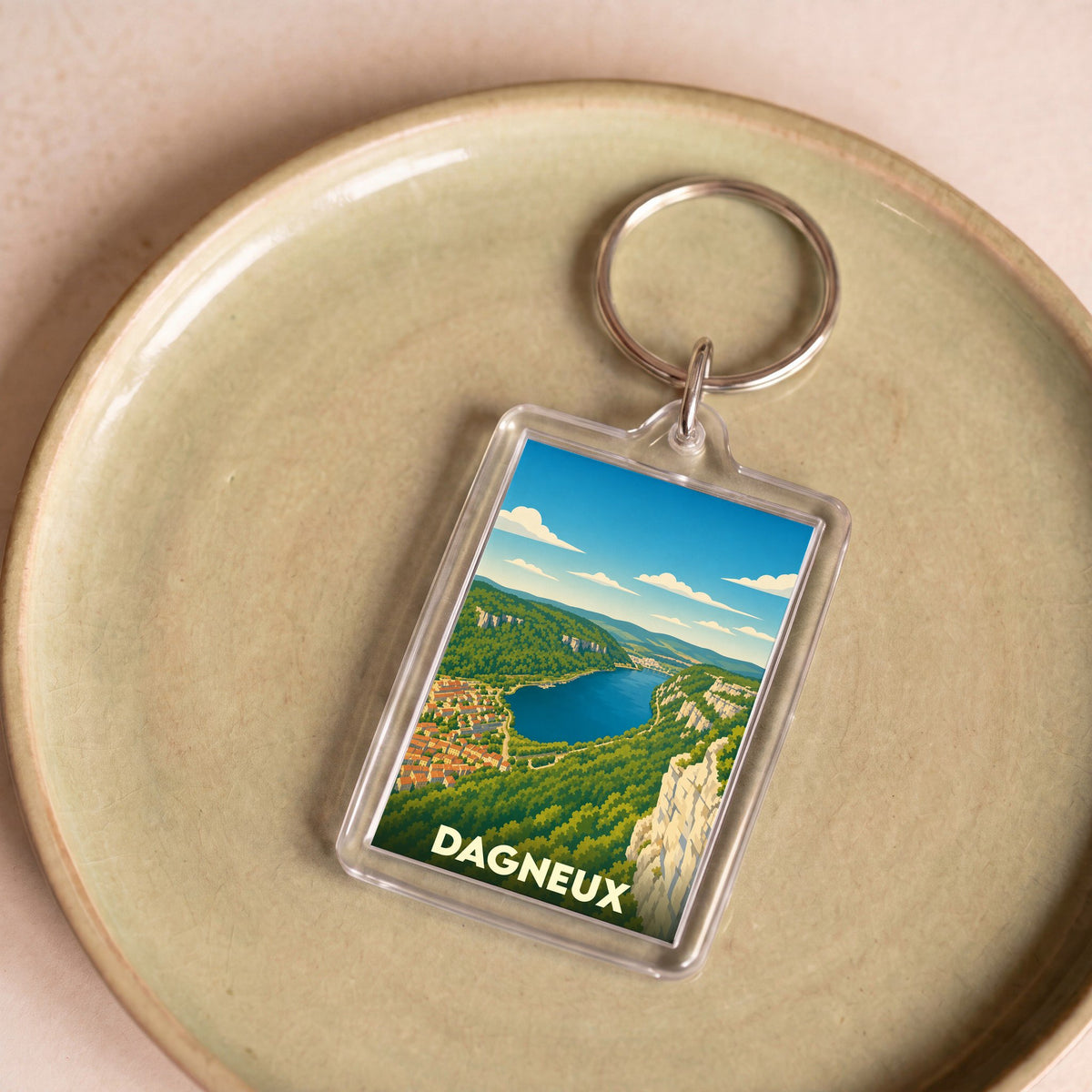 Porte-clés souvenir de la ville de Dagneux avec une illustration stylisée d'un paysage panoramique.