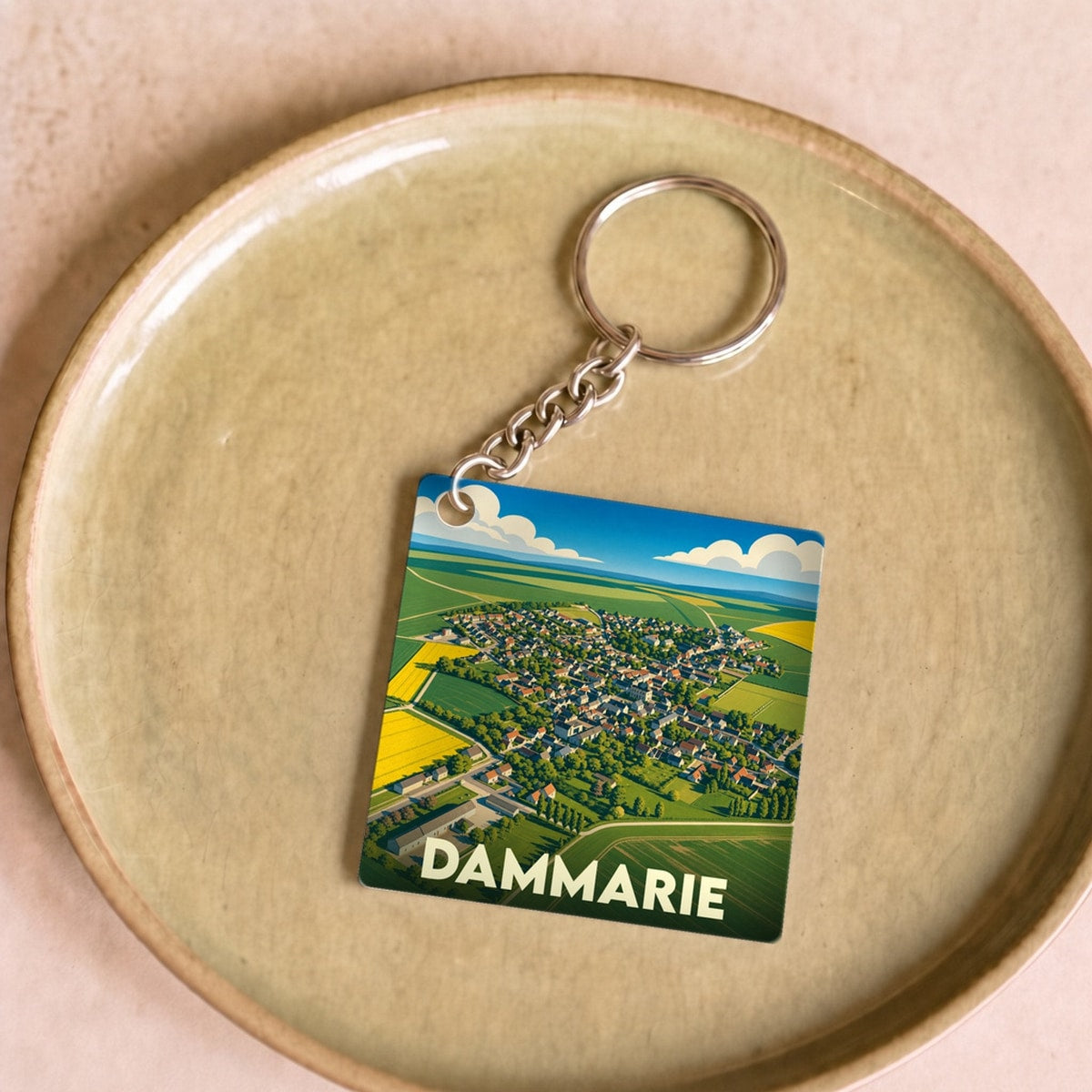 Porte-clés souvenir de la ville de Dammarie avec une illustration aérienne colorée et stylisée.