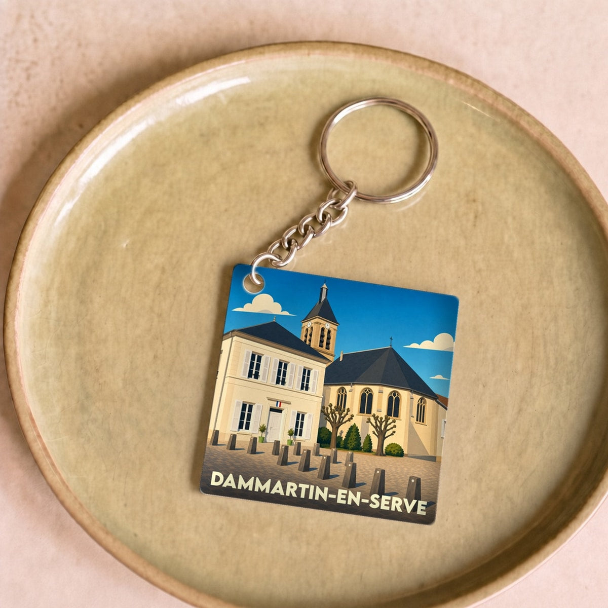 Porte-clés souvenir de la ville de Dammartin-en-Serve avec une illustration stylisée.