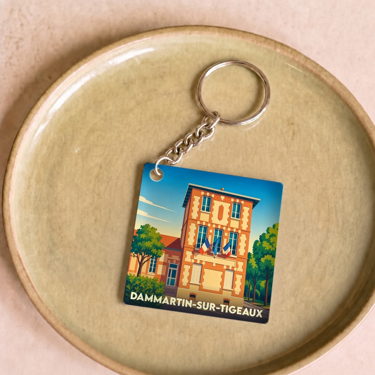 Porte-clés souvenir de la ville de Dammartin-sur-Tigeaux avec une illustration stylisée.