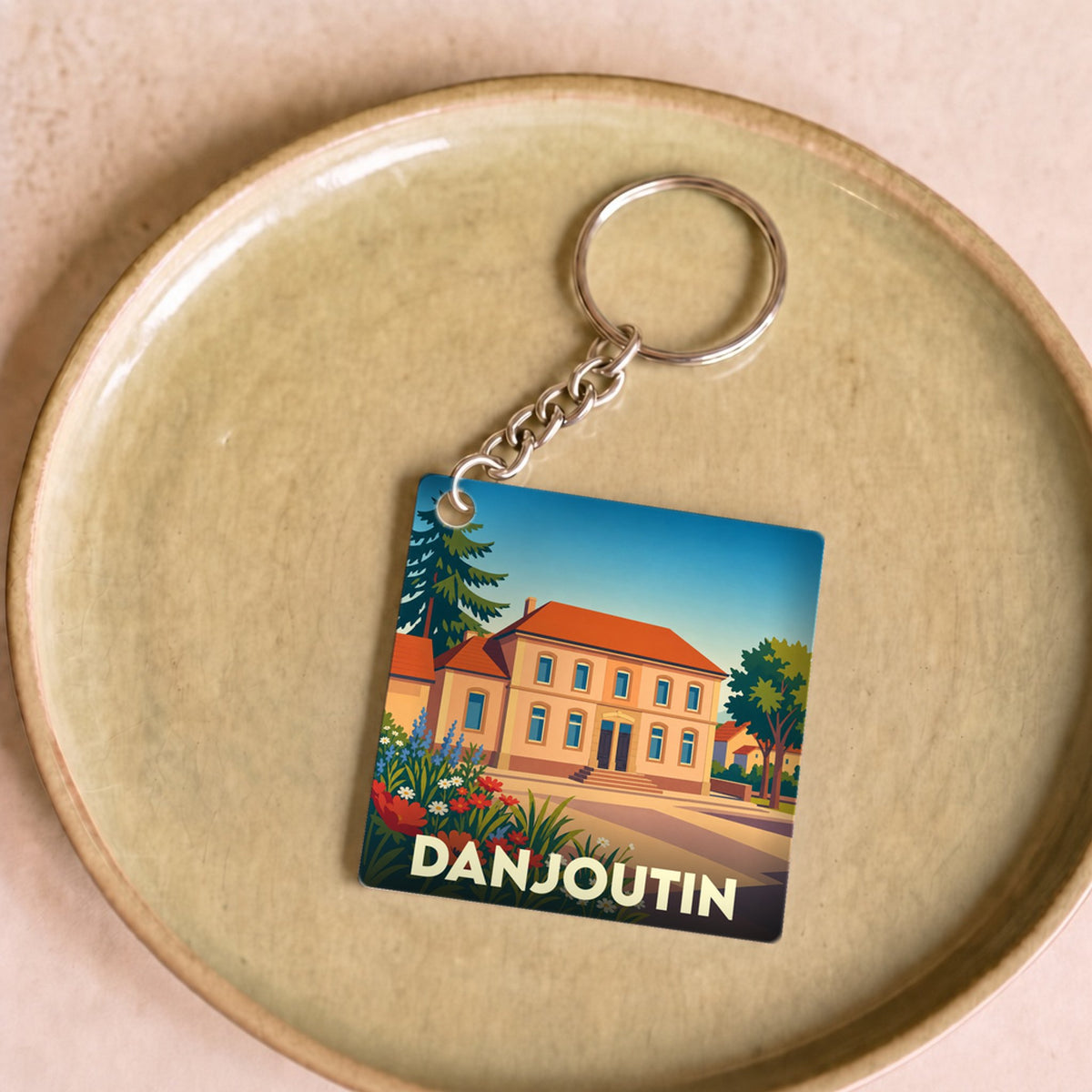 Porte-clés souvenir de la ville de Danjoutin avec une illustration stylisée.