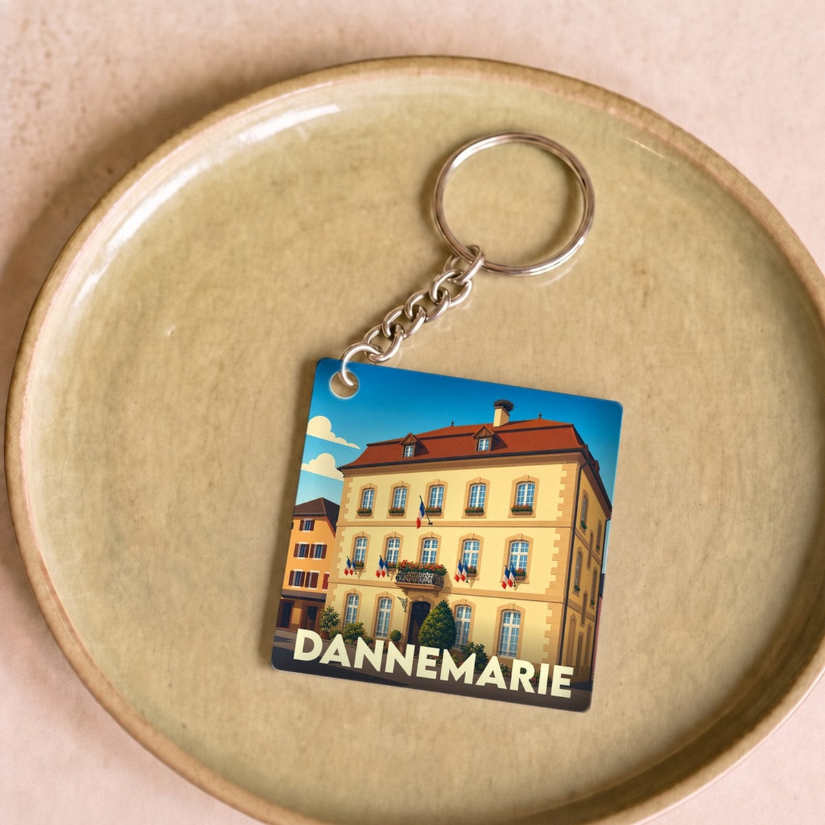 Porte-clés souvenir de la ville de Dannemarie avec une illustration stylisée.