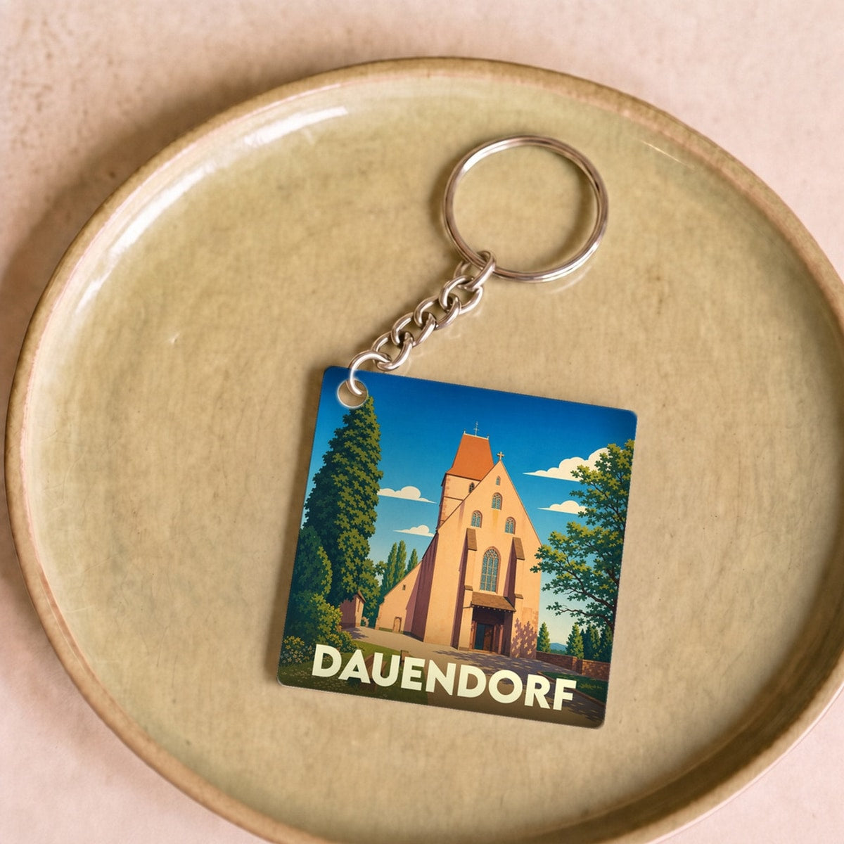 Porte-clés souvenir de la ville de Dauendorf avec une illustration stylisée de son église.