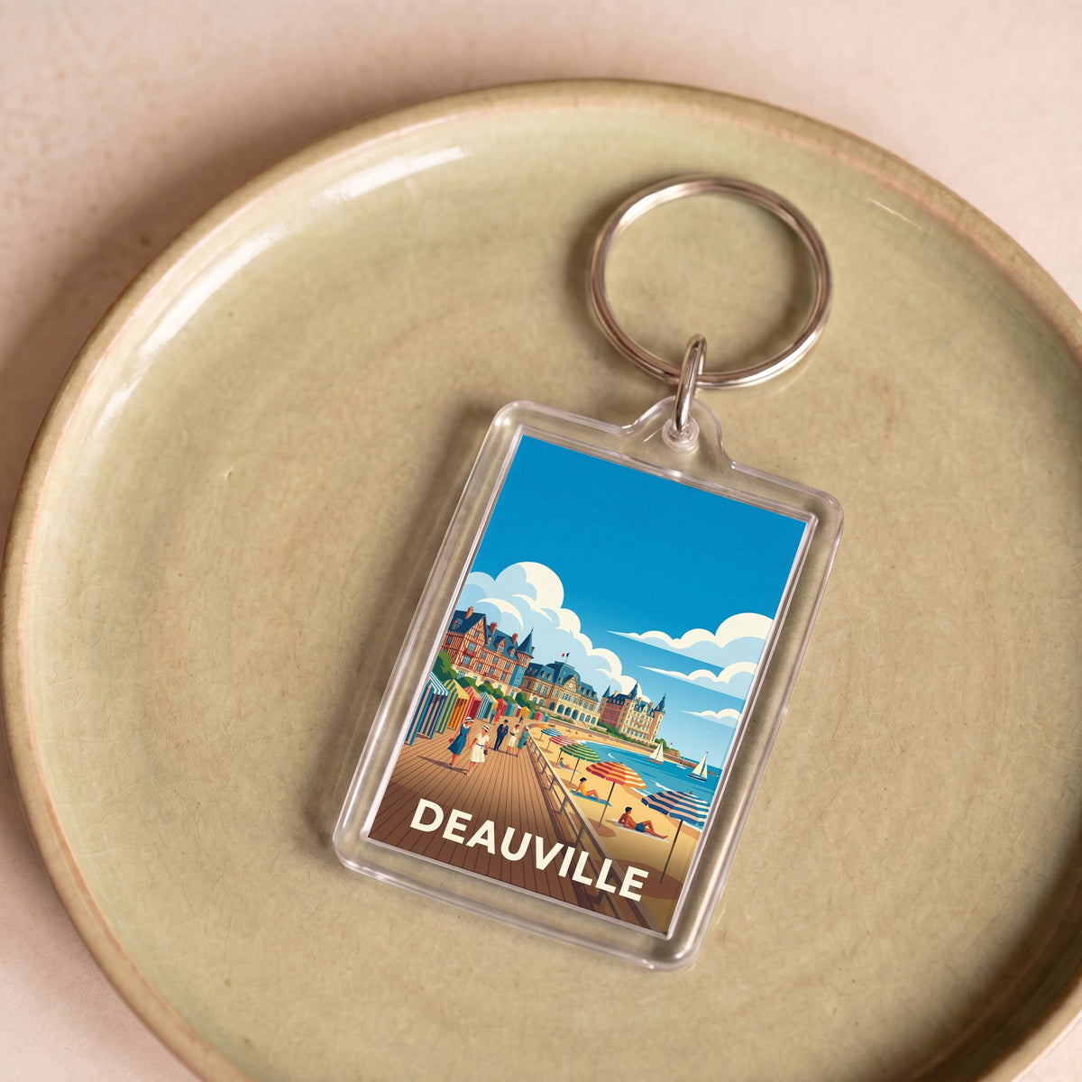 Porte-clés souvenir de la ville de Deauville avec une illustration stylisée de sa plage.