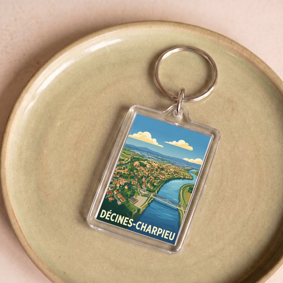 Porte-clés souvenir de la ville de Décines-Charpieu avec une illustration stylisée.